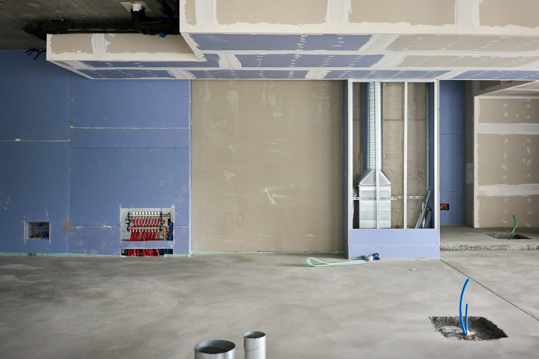 Bright house interior mid-renovation with freshly boarded and plastered walls